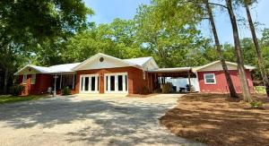 a home with a red house with a driveway at The Pecan House in Bainbridge