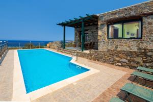 a villa with a swimming pool in front of a building at Elafonissi Villa with Amazing Sunset Views & Private Pool near Elafonissi in AmigdhalokeFálion