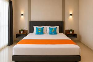 a bedroom with a large bed with blue and orange at SANS Vibes Grand Surya Jember Mini Zoo in Panti