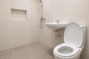 a bathroom with a toilet and a sink at SANS Vibes Grand Surya Jember Mini Zoo in Panti +21 photos