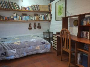 a bedroom with a bed and a desk and bookshelves at Casa del Aguacate Cumbaya - Tumbaco in Cumbayá