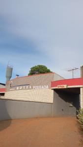 a building with a sign on the side of it at Stilus pousada in Sinop