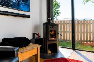 a wood stove in a living room with a table at Tiny House - Big Luxury in Wanaka