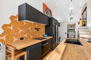 a kitchen with black cabinets and a wooden counter top at Tiny House - Big Luxury in Wanaka