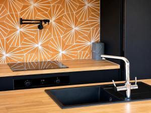 a kitchen with a counter with a sink and a wall at Tiny House - Big Luxury in Wanaka +22 photos