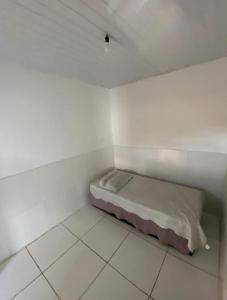 a small white room with a bed in it at Custo benefício Piri in Pirenópolis