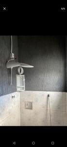 a ceiling fan and a shower in a bathroom at Custo benefício Piri in Pirenópolis