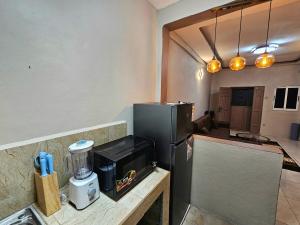 a kitchen with a counter with a black refrigerator at This apartment blends elegance and calm in Mills Center