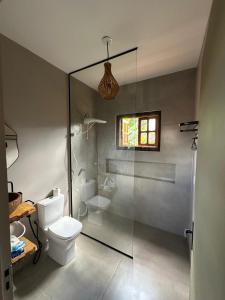 a bathroom with a toilet and a glass shower at Casa Jabu in Catas Altas +8 photos