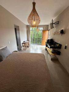 a bedroom with a large bed and a living room at Casa Jabu in Catas Altas