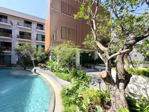 a building with a swimming pool in front of a building at After Rain Hotel in Chiang Mai