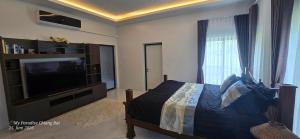 a bedroom with a bed and a flat screen tv at My Paradise Boutique Eco Resort Chiang Rai in Chiang Rai