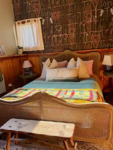a bedroom with a wicker bed with a bench next to it at CIRQUE 5 - Alpine Lodge built around a ski lift tower in Merrijig