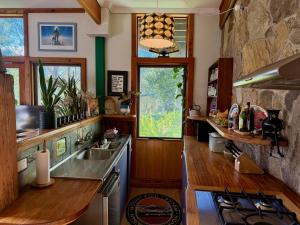 a kitchen with a stove and a stone wall at CIRQUE 5 - Alpine Lodge built around a ski lift tower in Merrijig