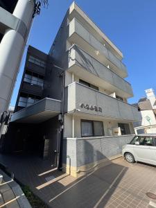 a building with a car parked in front of it at Haul Sakuramachi in Kumamoto