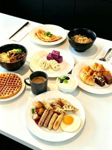 a table with plates of breakfast food on it at Paradox Kunshan in Kunshan
