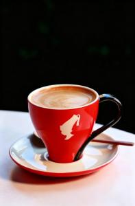 a red cup of coffee on a plate on a table at Paradox Kunshan in Kunshan