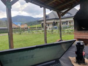 a laptop sitting on a table with a view of a field at Pensiunea Mușata Bucovinei in Vama