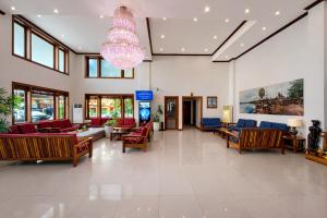 a lobby with couches and chairs and a chandelier at Cheathata CTS Hotel Siem Reap in Siem Reap