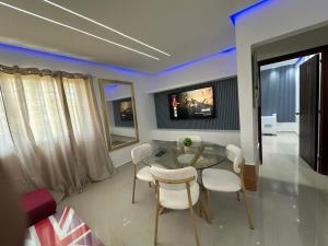 a dining room with a glass table and white chairs at Ts02 torre B in La Romana
