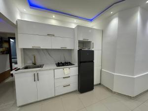 a kitchen with white cabinets and a black refrigerator at Ts02 torre B in La Romana +2 photos