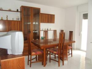 a dining room with a table and chairs and a television at Noria 305 in Alcossebre