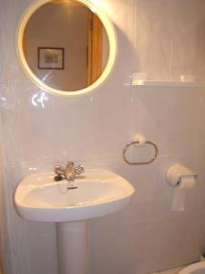 Baño blanco con lavabo y espejo en Noria 305, en Alcossebre