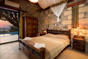 ein Schlafzimmer mit Bett und Balkon mit Aussicht in der Unterkunft Sea-Sunset Views Villa Lefkothea with Private Pool near Elafonissi in AmigdhalokeFálion