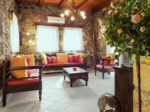 ein Wohnzimmer mit Sofas und einem Tisch in der Unterkunft Sea-Sunset Views Villa Lefkothea with Private Pool near Elafonissi in AmigdhalokeFálion