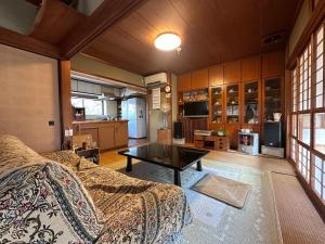 a living room with a couch and a table at 空港近くの温泉宿 翻車魚庵 in Kirishima