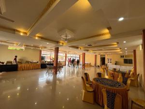 a large room with tables and chairs and a cafeteria at Hotel GMP in Hoshangābād