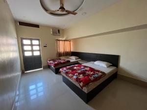 two beds in a room with a ceiling at Hotel GMP in Hoshangābād
