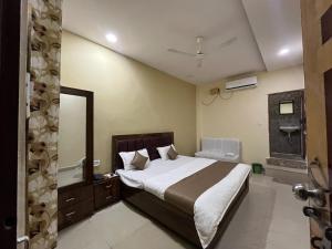 a bedroom with a large bed and a bathroom at Hotel GMP in Hoshangābād