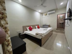 a bedroom with a bed with red pillows on it at Hotel GMP in Hoshangābād +3 photos