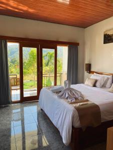 a bedroom with two beds and a balcony at Umaku Bali Homestay in Munduk