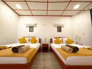 two beds in a room with yellow and white at Seven Minutes Ella by SANS in Ella +61 photos