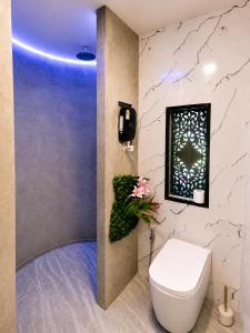 a bathroom with a toilet and a picture on the wall at Samui Hills Resort in Taling Ngam Beach
