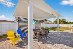 a patio with a table and chairs under a white canopy at Downtown Breeze in Cape Coral