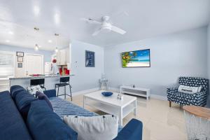 a living room with a blue couch and a kitchen at Downtown Breeze in Cape Coral