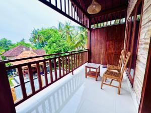 a balcony with a chair and a table on it at Dtegal Private Villa in Klungkung
