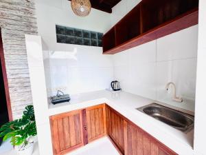 a kitchen with wooden cabinets and a sink at Dtegal Private Villa in Klungkung