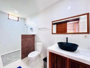 a bathroom with a black sink and a toilet at Dtegal Private Villa in Klungkung +10 photos
