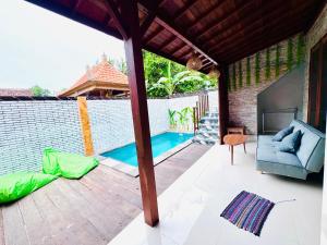 a patio with a couch and a swimming pool at Dtegal Private Villa in Klungkung