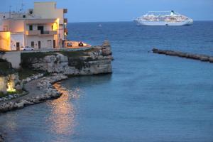 a cruise ship in the water next to a building at Home Holiday Salento Monica's House in Otranto