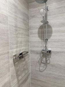 a shower with a shower head in a bathroom at Hermes Haven Hotel in Pattaya South