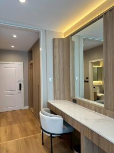 a bathroom with a mirror and a white chair at Hermes Haven Hotel in Pattaya South