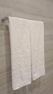 two white towels on a towel rack on the floor at Hermes Haven Hotel in Pattaya South