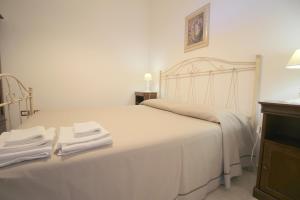 a bedroom with a white bed with two towels on it at Home Holiday Salento Monica's House in Otranto