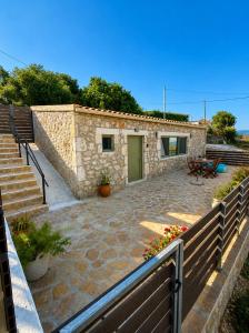 a stone house with a green door and a patio at Sea salt house in Zambelláta
