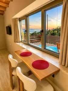 a dining room with a table and a large window at Sea salt house in Zambelláta